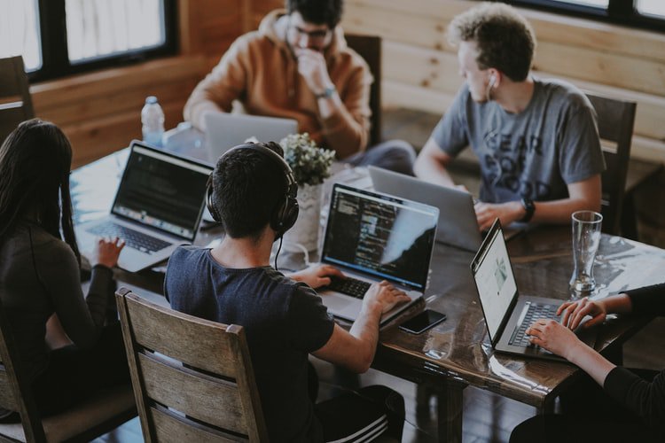 5 persons with laptop sitting in a table